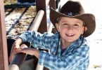 Wish Kid Zack at horse stalls at farm