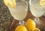 Two glasses of lavender lemon cooler with sugared rims and lemon slices