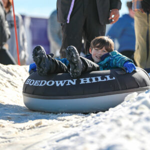 Child sledding down Hoedown Hill