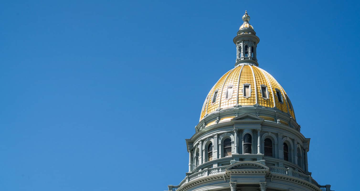 Gold-domed building against a clear blue sky, featuring ornate architectural details.