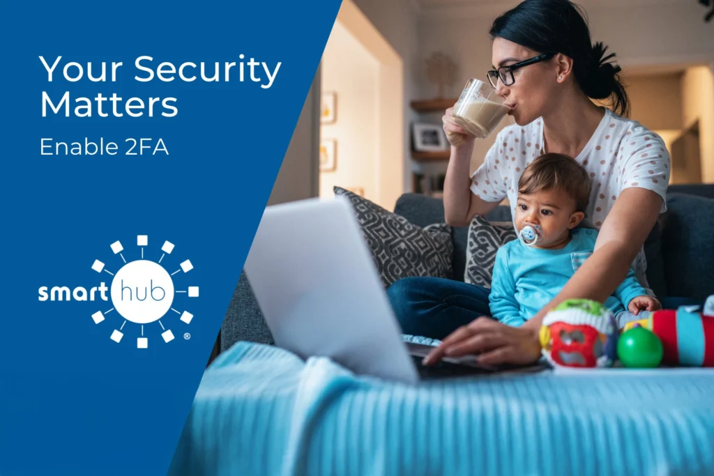 A woman sits on a couch with a toddler, working on a laptop and drinking from a glass. A blue banner reads, “Your Security Matters. Enable 2FA. SmartHub.”.